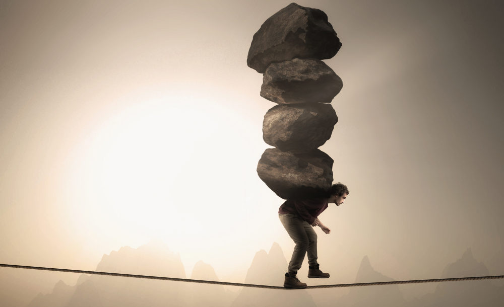 Man,Carries,A,Stack,Of,Big,Rocks,While,Balancing,On