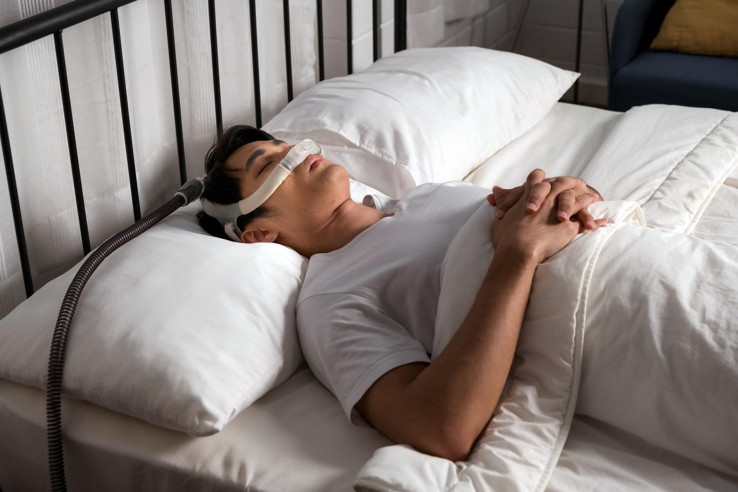 Asian,Man,Sleeping,Calmly,With,Cpap,Nasal,Mask,In,Bed,