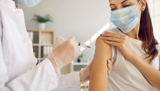 Professional,Nurse,In,White,Gloves,And,Facemask,Giving,Flu,Shot
