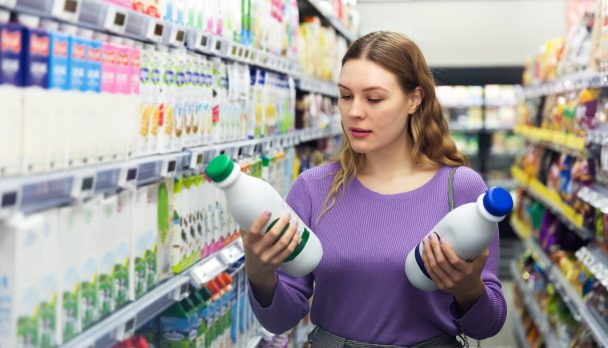 Portrait,Of,Young,Smiling,Woman,Customer,Choosing,Milk,And,Dairy