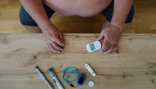 Diabetic,Overweight,Man,With,Diabetes,Supplies,And,Devices,On,Table.